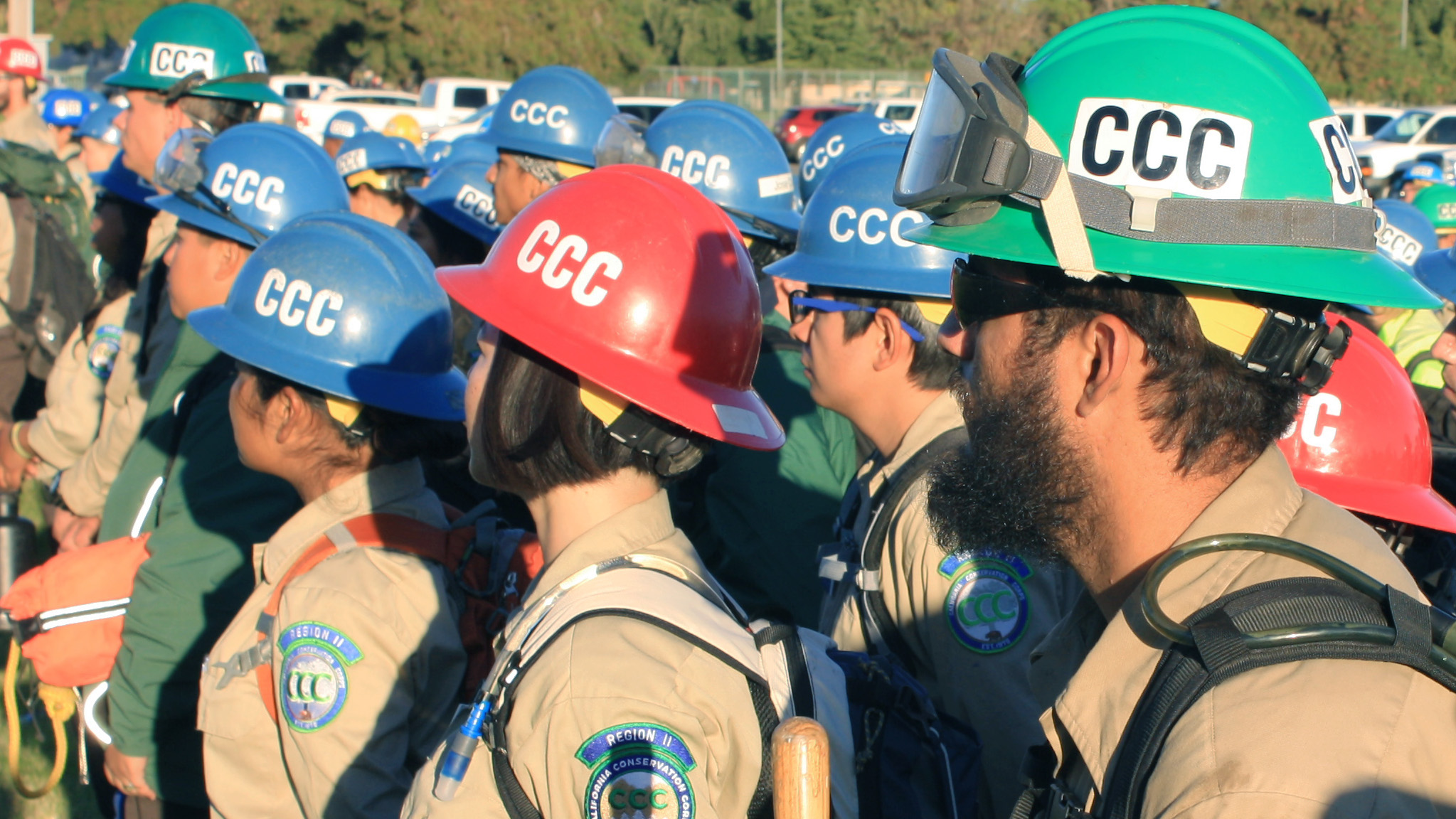 A group of recruits wearing CCC hardhats stand in lines.