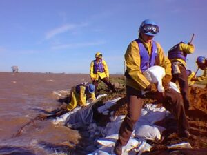 Corpsmembers place sandbags along levee