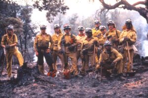 Corpsmembers in full wildland fire equipment post for photo