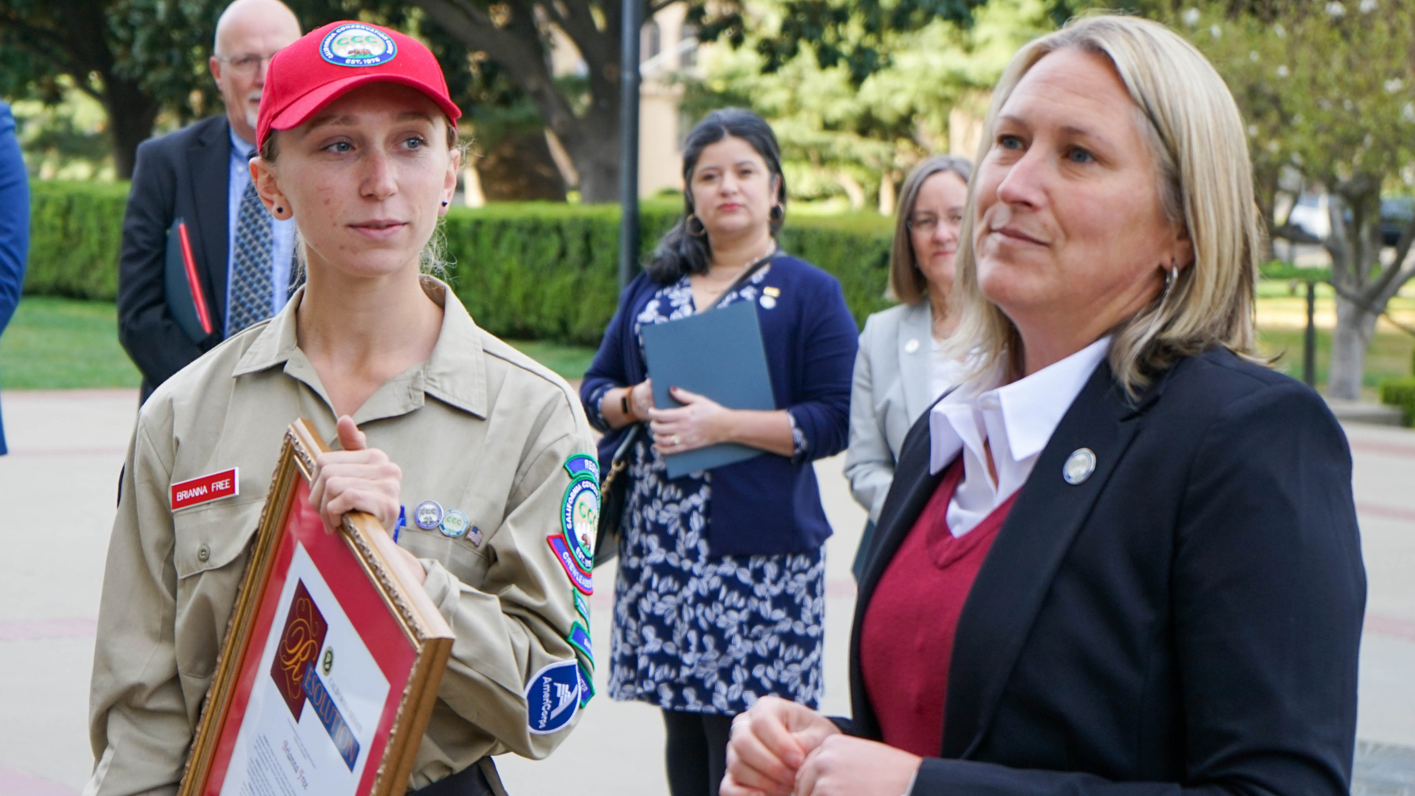 woman holding plaque standing next to another woman