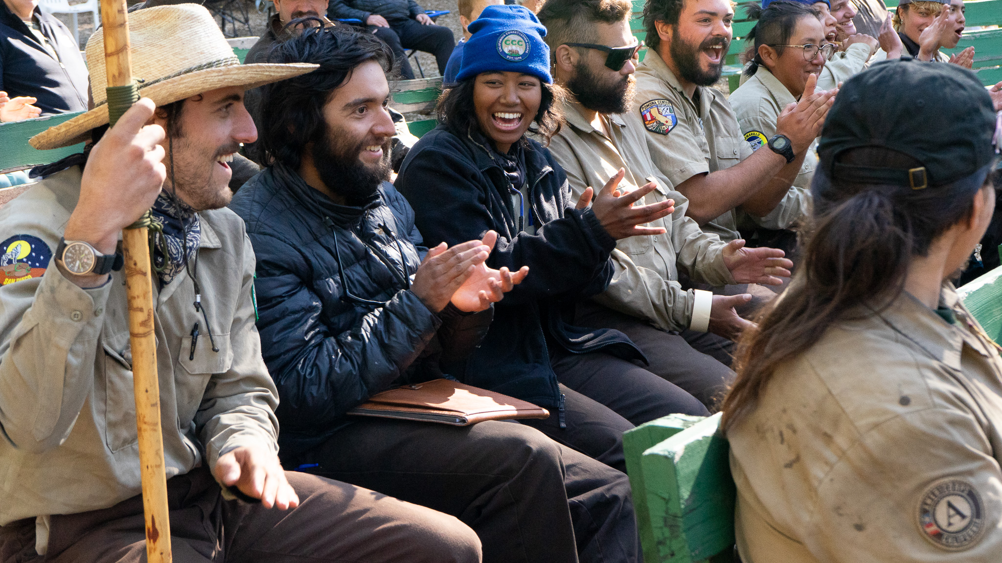 Backcountry Corpsmembers clap and smile, celebrating the end of the season. 