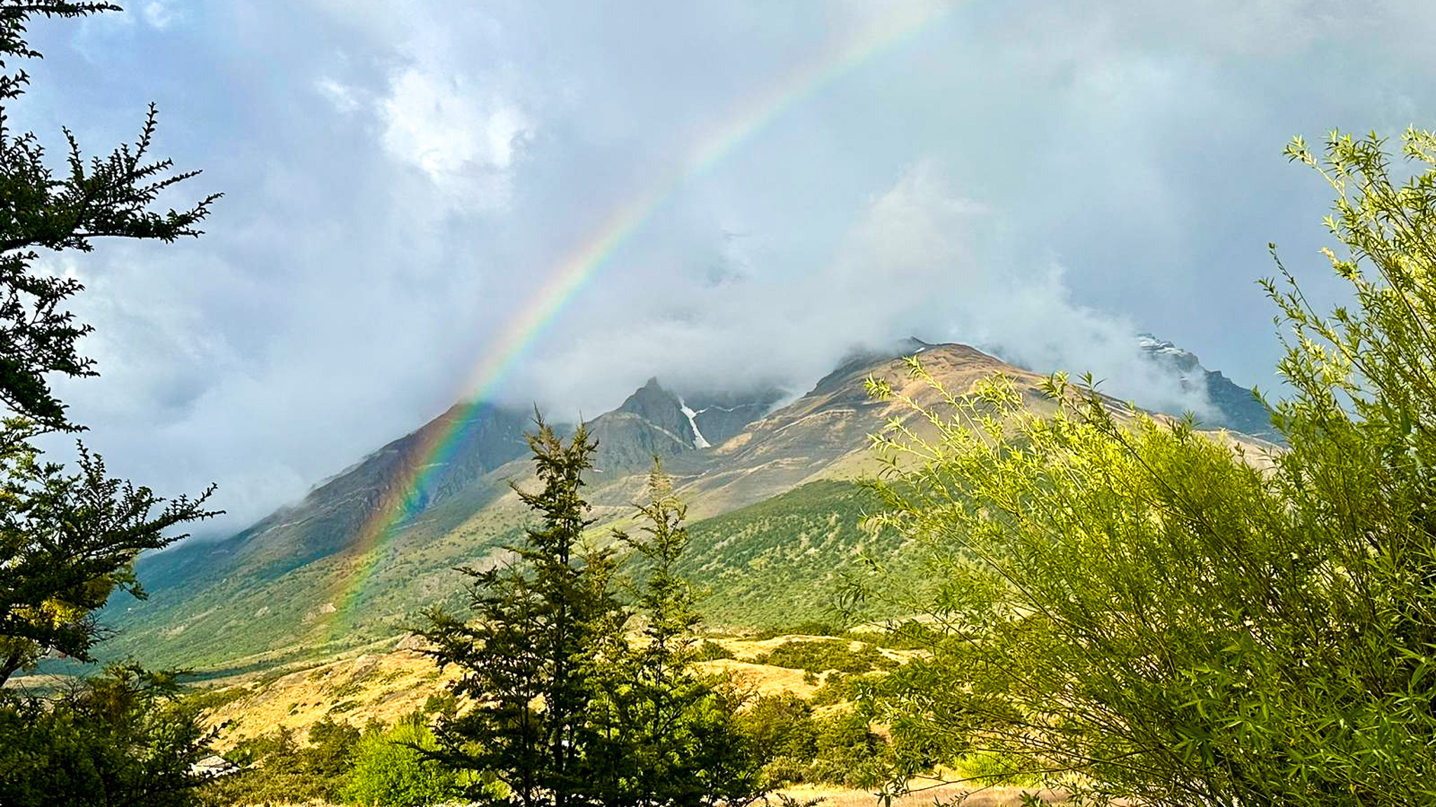 A rainbow appears over the Andean Mountain Range in Torres Del Paine National Park.