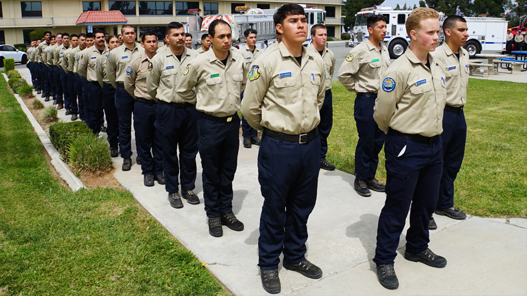 firefighters standing in formation outside in uniform