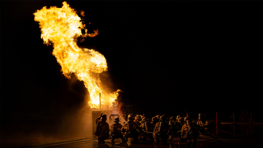 large flame with firefighters working nearby