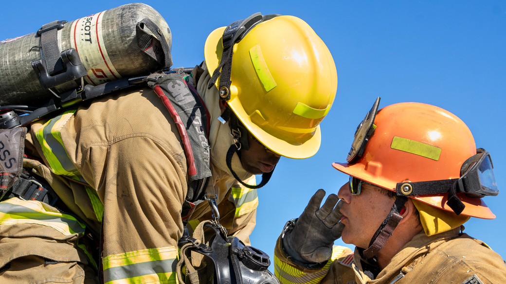 firefighter leaning in so instructor can yell instructions to them