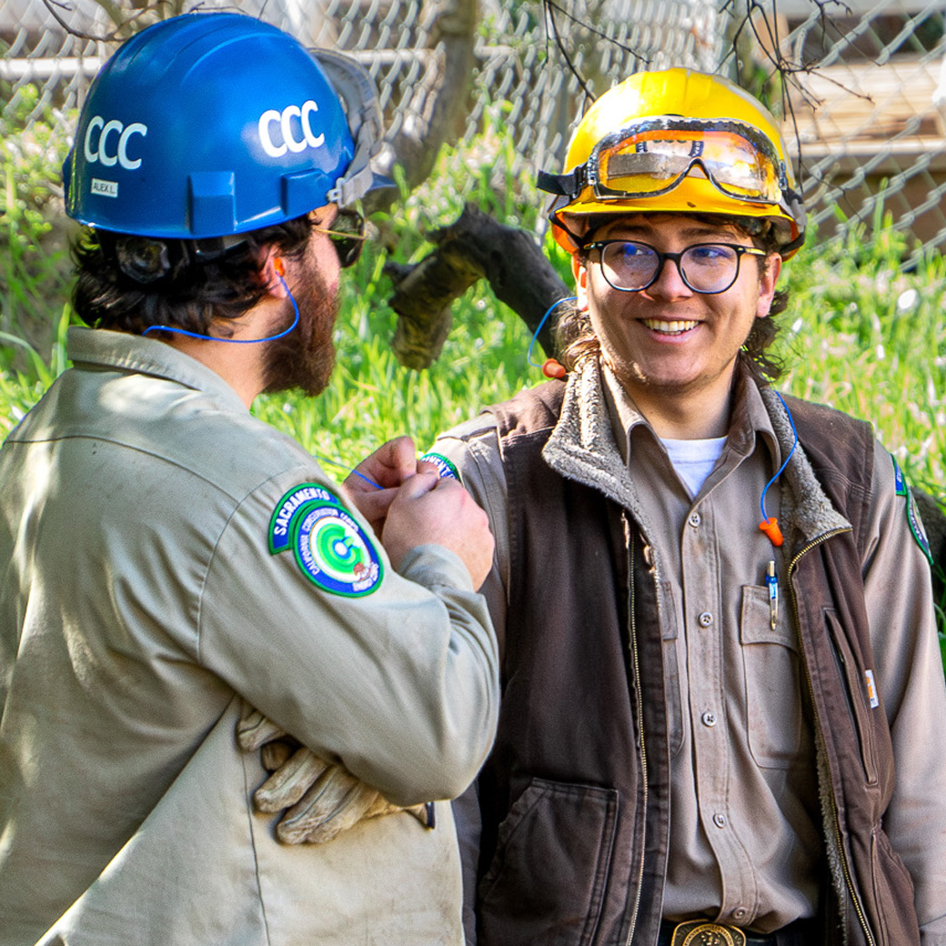 male corpsmembers talking to male staff member smiling while in the outdoors